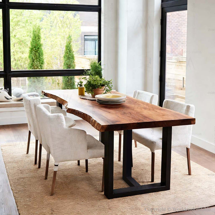 Dining room with a wooden table and white chairs near large windows.