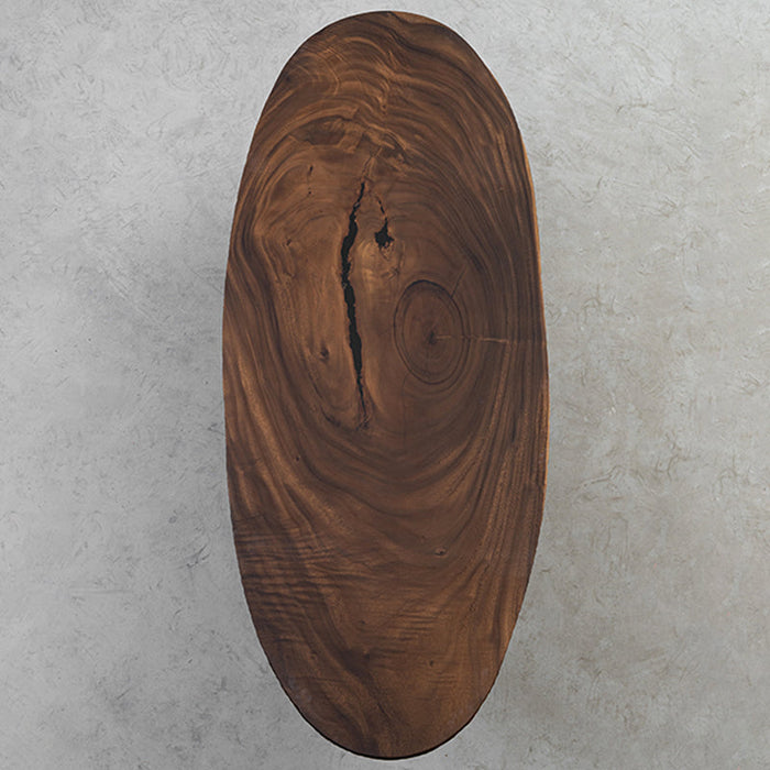 Natural walnut wood elliptical dining table made from solid slabs with smooth finish.