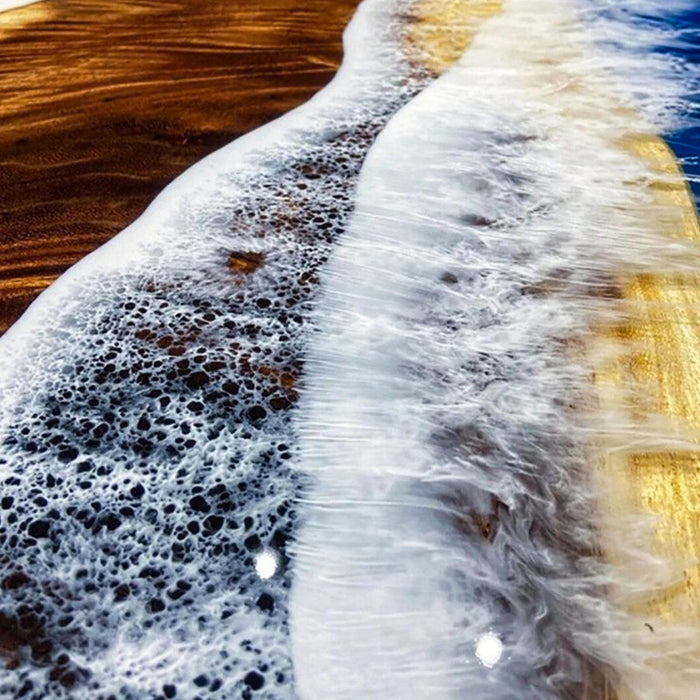 Close-up of ocean waves crashing onto a sandy shore with foam.