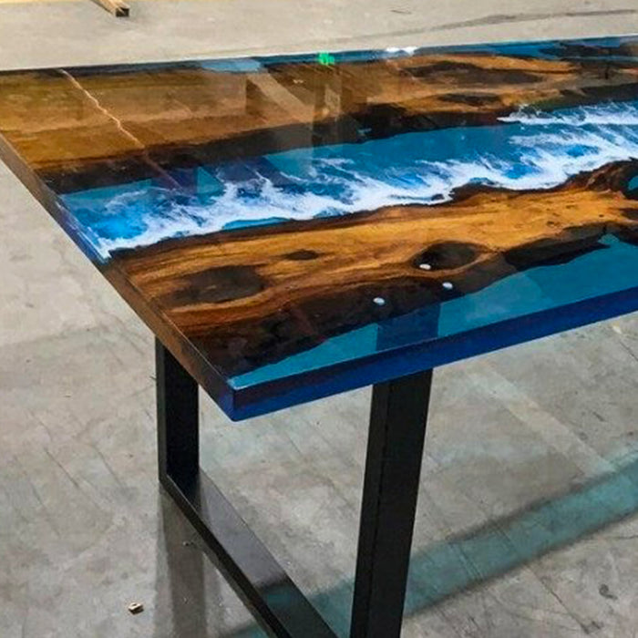 Wooden table with blue resin finish on a concrete floor