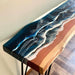 Wooden table with blue and white resin design on a neutral background