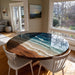 Artistic epoxy river table featuring detailed ocean wave patterns