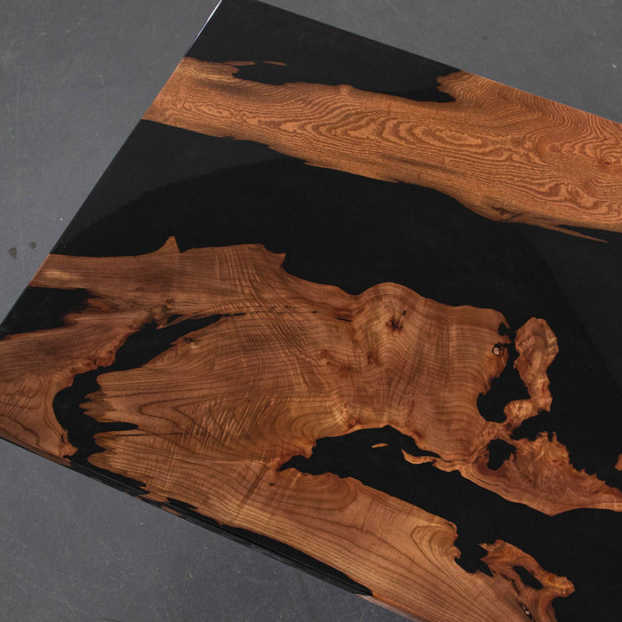 Wooden surface with black resin inlay on a dark background