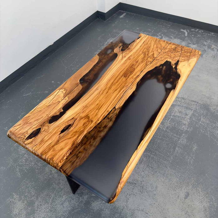 Wooden coffee table with black resin finish on a gray surface