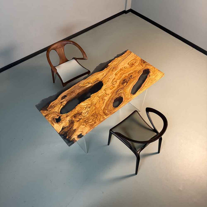 Wooden table with natural grain and two chairs in a minimalistic setting