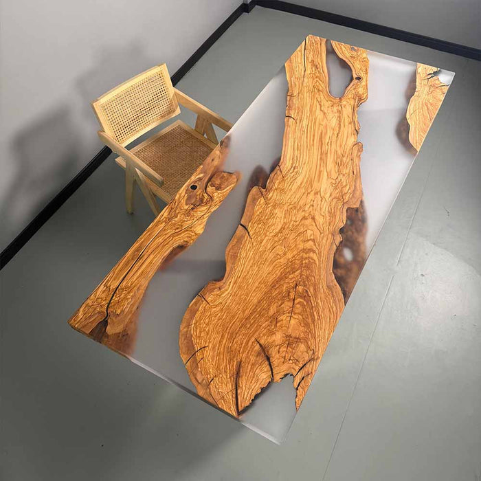 Wooden table with natural grain pattern and a chair on a gray floor.
