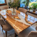Luxury olive wood and white resin river dining table in modern interior setting with elegant chairs