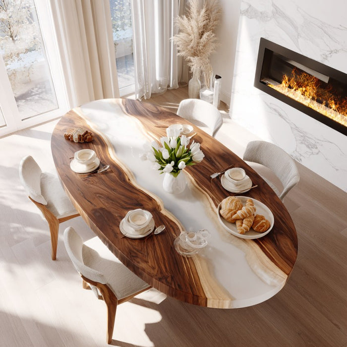 Wooden dining table with white chairs in a bright room with a fireplace.