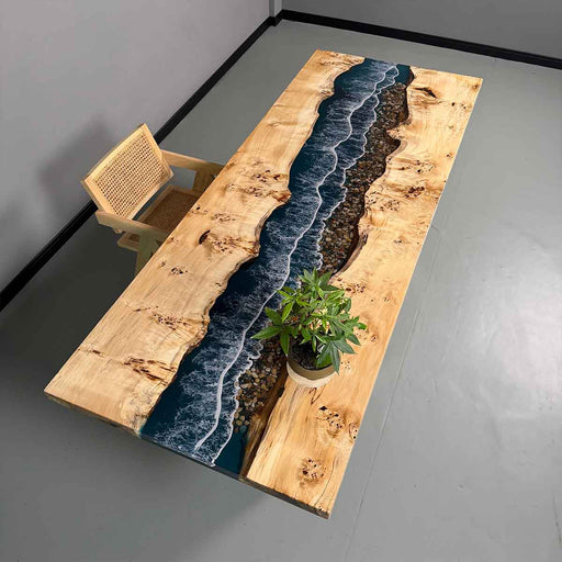 Wooden table with embedded blue river design on a gray floor.