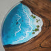 Close-up of premium black walnut epoxy river table showing rich chocolate wood tones and crystal-clear blue resin.