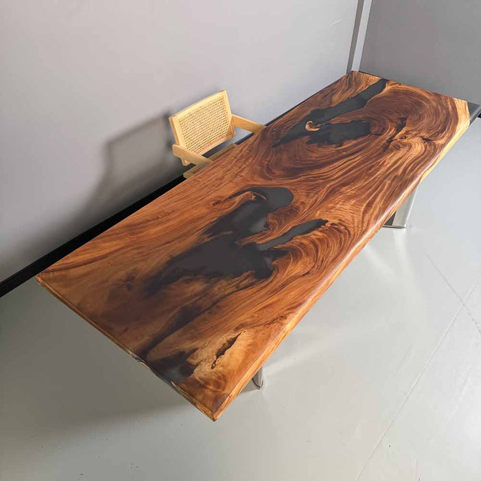 Wooden desk with a wicker chair against a plain wall