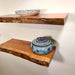 Two wooden shelves with ceramic pots on a plain background
