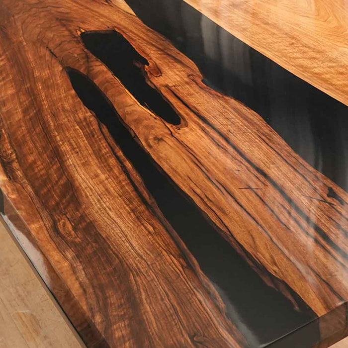 Wooden table with a black resin inlay