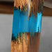 Close-up of a wooden vase with blue and gold resin finish