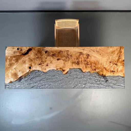 Wooden desk with a natural finish and embedded stone, against a neutral background.