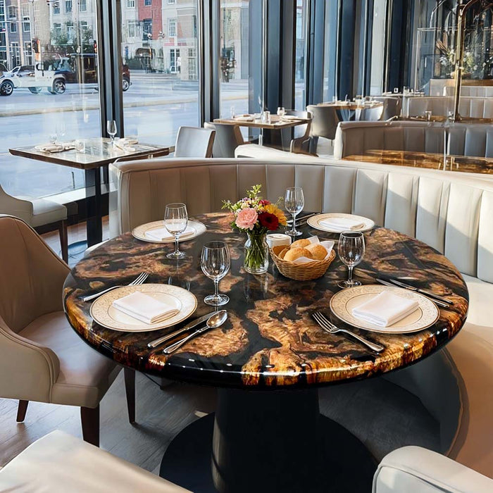 Dining table set with plates, glasses, and a vase of flowers in a modern restaurant setting.