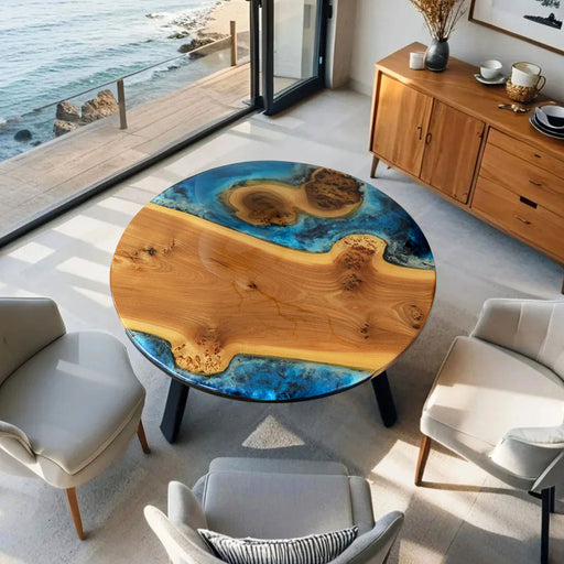Round wooden table with blue resin inlay in a modern living room with ocean view