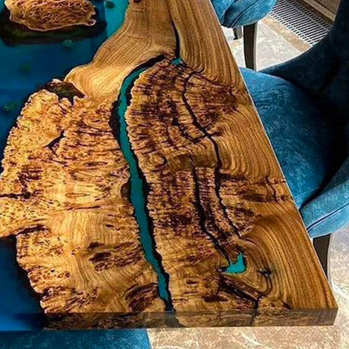 Wooden cutting board with a natural grain pattern and embedded blue resin on a blue surface.
