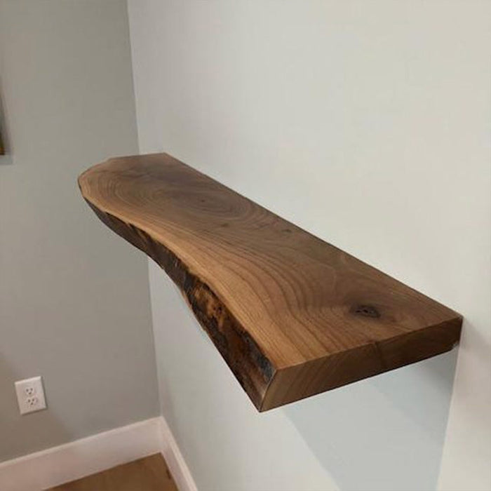 Wooden shelf mounted on a white wall