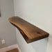 Wooden shelf mounted on a white wall