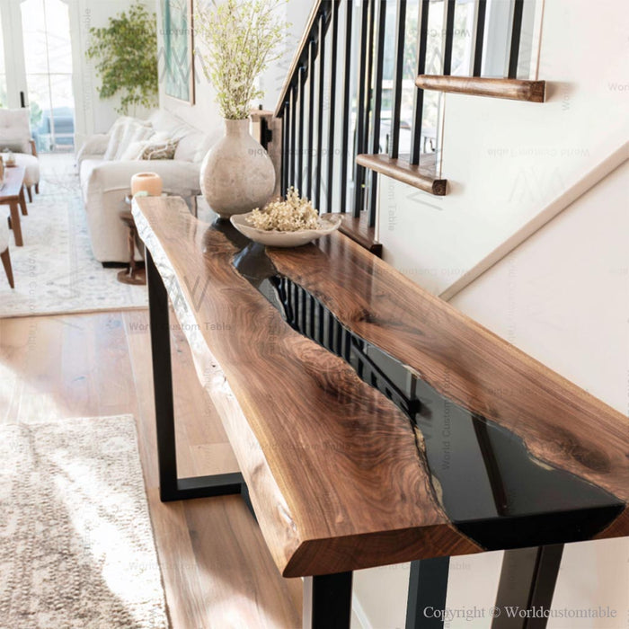 Rustic luxury black walnut epoxy console table in a foyer with decorative items