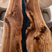 Rustic modern dining room with epoxy river table and live edge design.