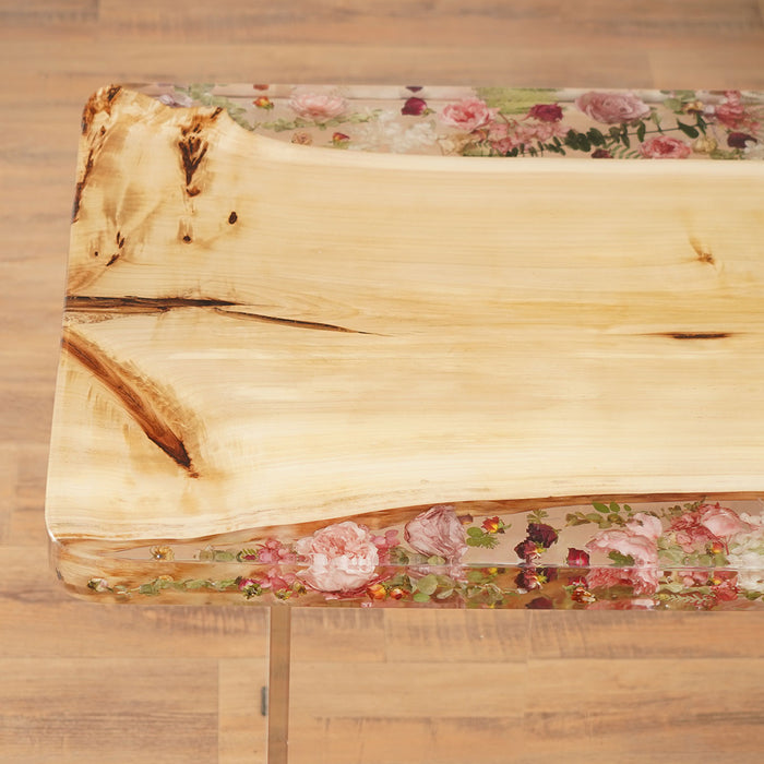 Wooden cutting board with floral resin design on a wooden surface