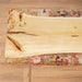 Wooden cutting board with floral resin design on a wooden surface