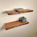 Two wooden shelves with decorative items against a beige wall