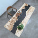 Wooden table with black resin inlay and a chair on a concrete floor.
