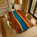 Dining room with a wooden table featuring a river design, surrounded by chairs.