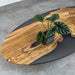 Wooden coffee table with a plant on a gray floor