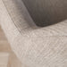 Close-up of a textured gray chair armrest on a wooden floor.