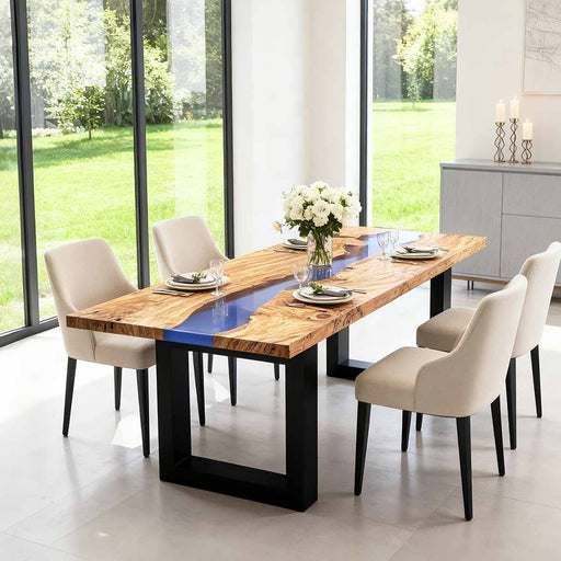 Dining table with a wooden top and black legs in a modern room with large windows.