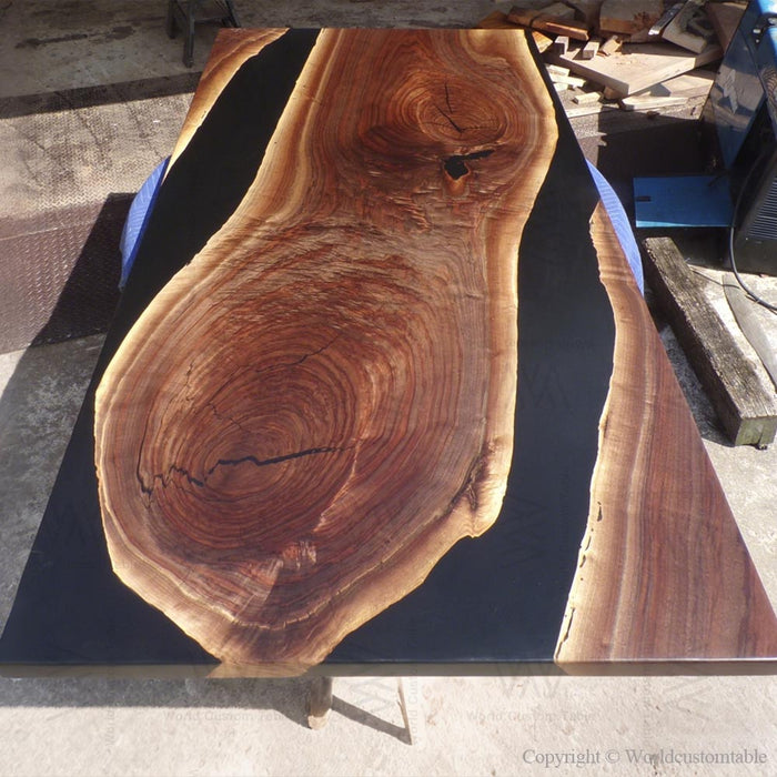 Solid wood black epoxy dining table serving as a statement piece in modern interiors.