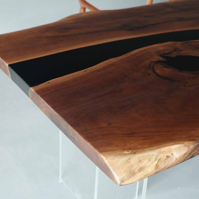 Wooden table with a black resin inlay on a light gray background