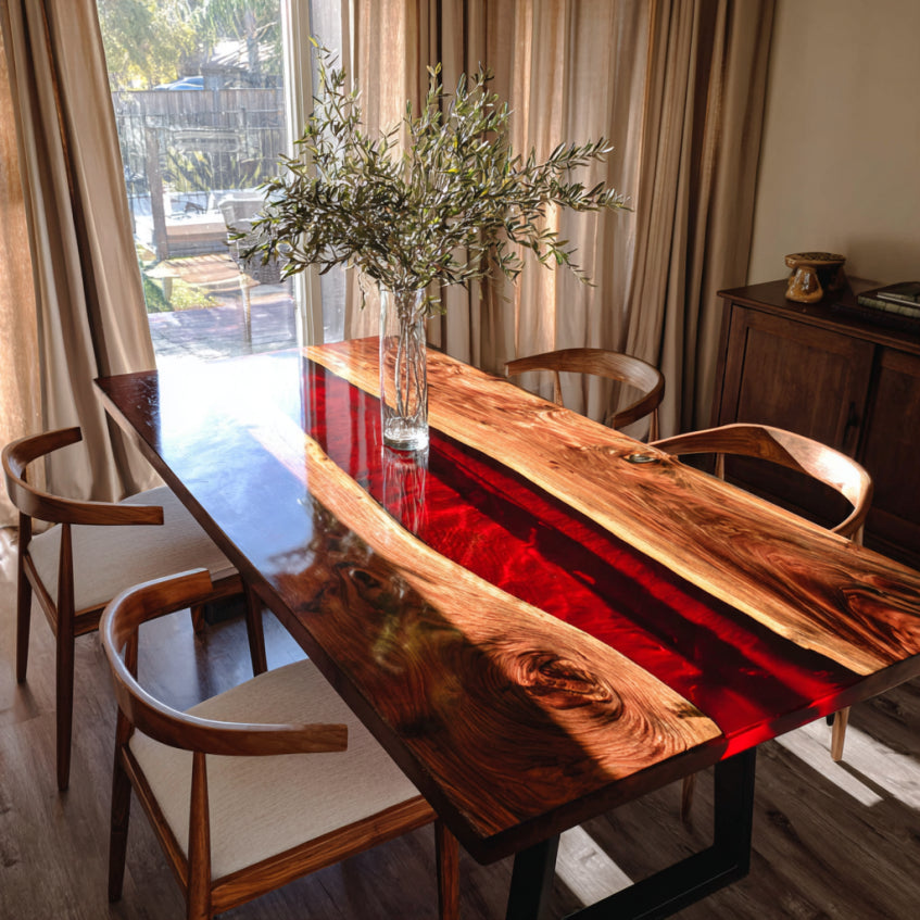 Dining room with a wooden table and chairs, featuring a vase with greenery.