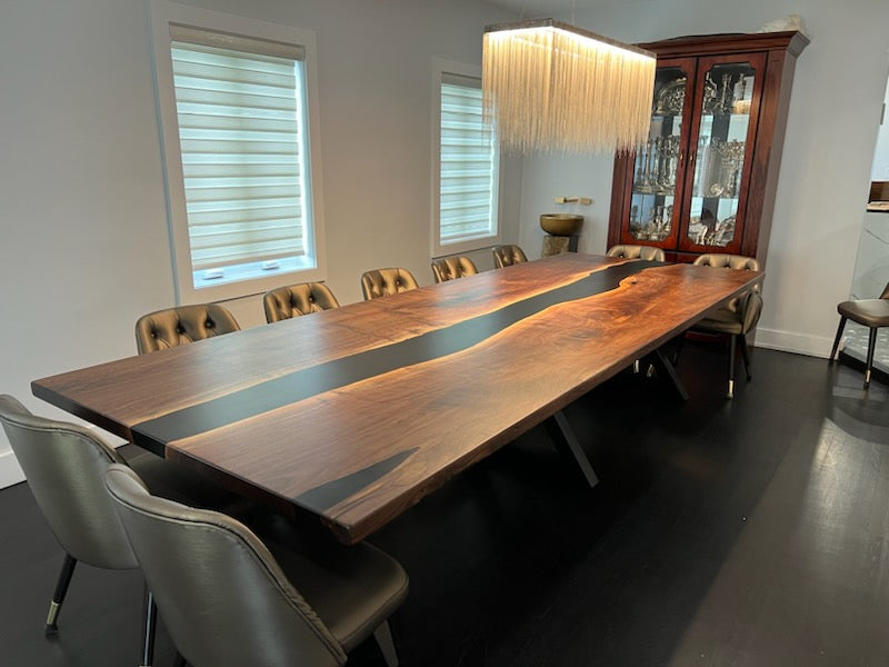 Long wooden dining table with chairs in a modern room.