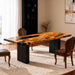 Wooden dining table with black legs in a room with chairs and decor.