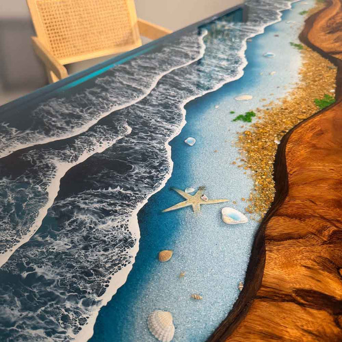Tabletop with a beach-themed design featuring water, sand, and starfish.