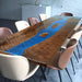 A captivating epoxy resin wood river table with dark wood grain and vibrant blue epoxy resin inlays, creating a striking visual effect.