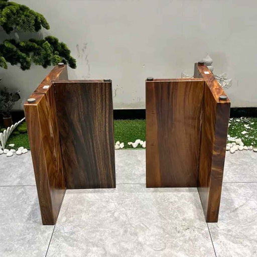 Two wooden podiums on a tiled floor with a white wall and plants in the background.