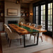 Dining room with a long wooden table and chairs near a fireplace.