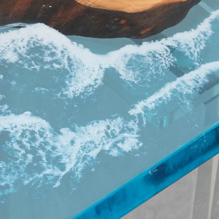 Close-up of a glass table with water and a rock, viewed from above.