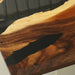 Close-up of a wooden surface with a black object casting a shadow