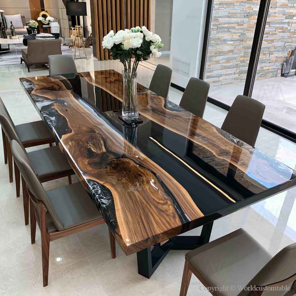 Luxury black walnut dining table featuring a deep black epoxy river with natural live edge wood in a modern dining room.