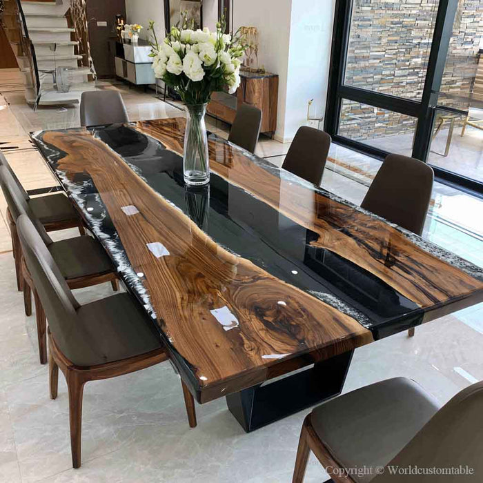 Solid black walnut river table combining organic live edge wood with a sleek black epoxy resin centerpiece.