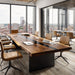 Modern office conference room with a long wooden table and chairs, large windows overlooking a cityscape.