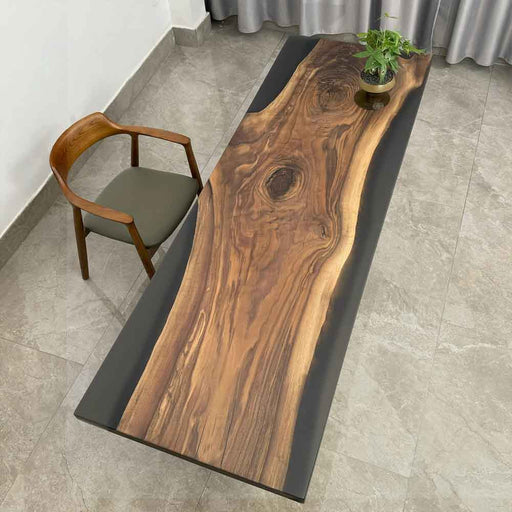 Wooden dining table with black resin finish in a room setting