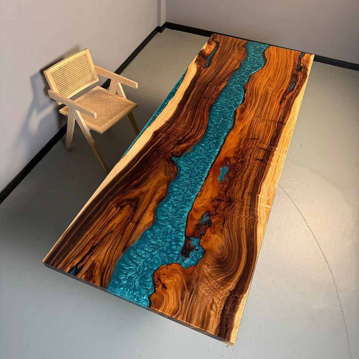 Wooden table with blue resin inlay and a chair in a minimalistic setting